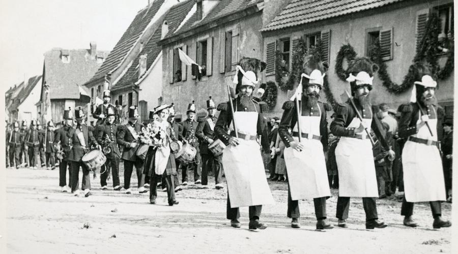 Sapeurs, suivis de tambour-major, clique, Colonel, Drapeau, Cantinière et voltigeurs du 69e régiment d'Infanterie (époque : 1867). 
