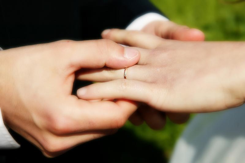 Un homme qui passe une alliance au doigt d'une femme