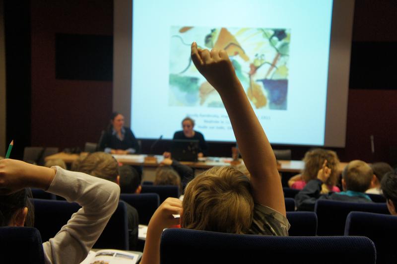 Enfant levant le doigt durant la conférence-découverte au Frac Alsace, mars 2014