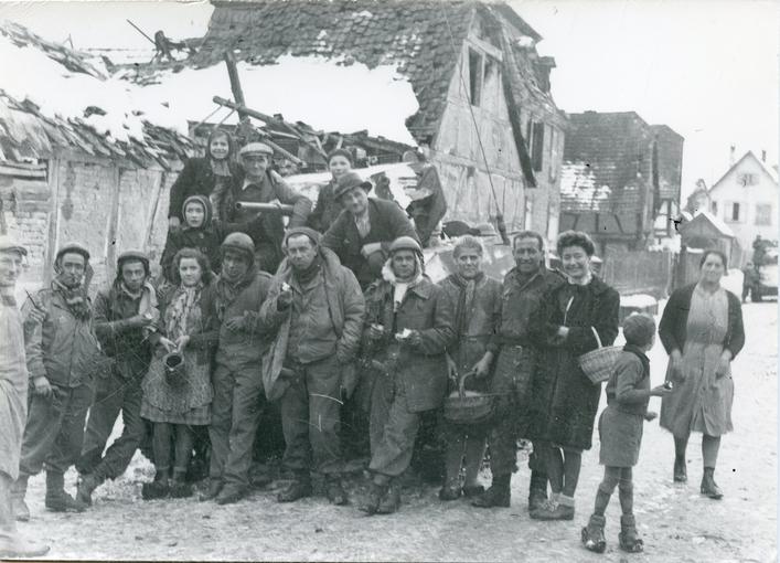 Les habitants de Sélestat ont réservé un accueil chaleureux aux soldats américains ; ils posent devant leur char dans un quartier en ruines. 