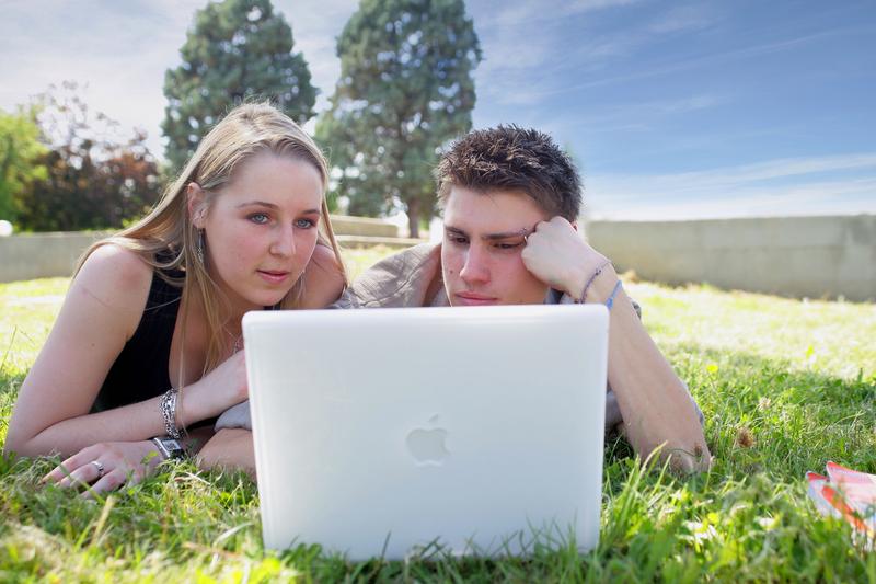 Couple de jeunes derrière un ordinateur