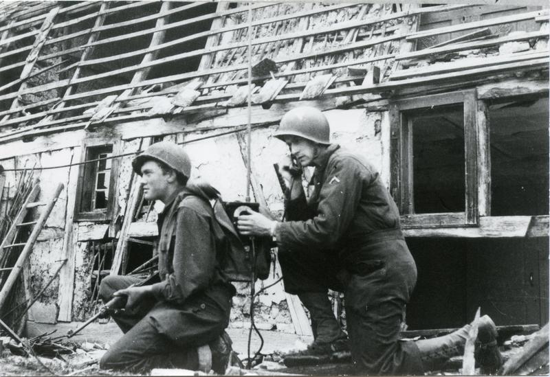 Deux soldats américains devant une maison en ruines.