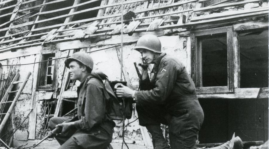 Deux soldats américains devant une maison en ruines.