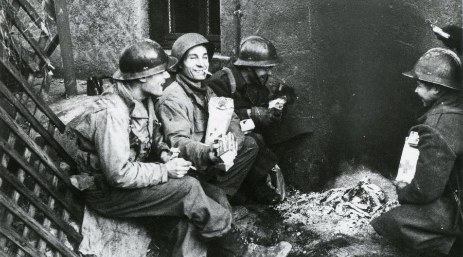 Des soldats américains prennent une pause et se réchauffent autour d'un feu de fortune.