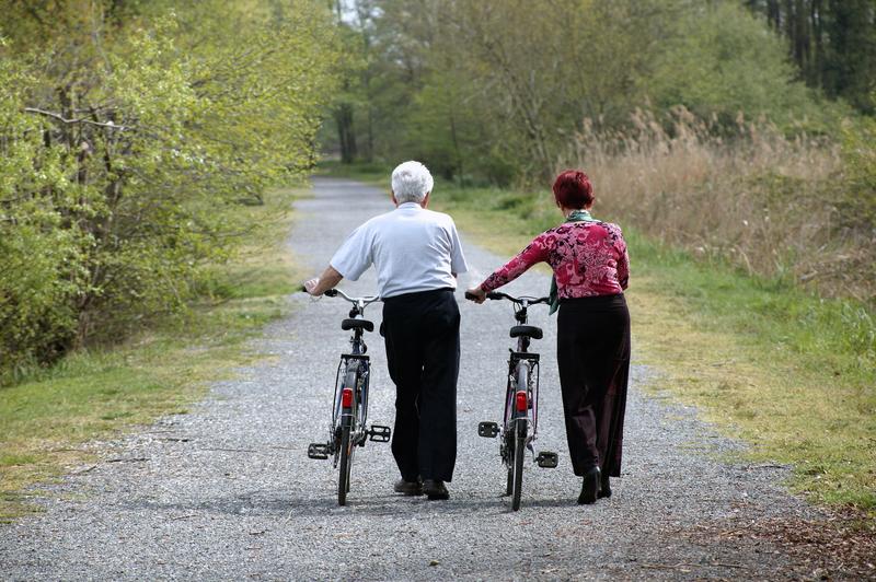 Deux personnes âgées qui marchent avec des vélos