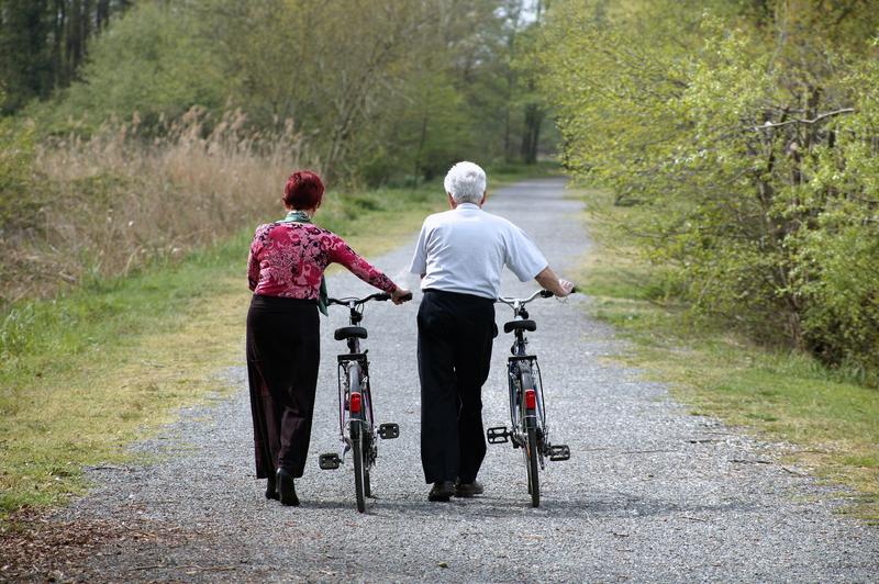 Deux personnes âgées qui marchent avec des vélos