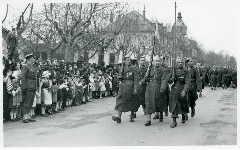 La foule des Sélestadiens rend hommage aux soldats et corps d’armées qui défilent. De nombreux enfants arborent le costume traditionnel alsacien.