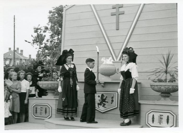 Des jeunes alsaciens et alsaciennes dans leurs costumes traditionnels, devant le Cénotaphe. 